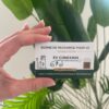 Card for EV charging hardware: says 'BORNE DE RECHARGE POUR VE' with EV CONEXION logo, held by a hand in front of green plants (French text on card).